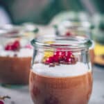 Veganer Schokopudding im Glas mit Kokoshaube und Johannisbeeren